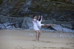 Zwei Tanzende bei einer Hebefigur an einem felsigen Strand in weißem SCHIESSER-Feinripp
