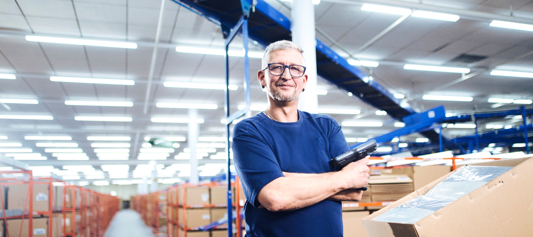 Ein Mann in blauem T-Shirt schaut in die Kamera.